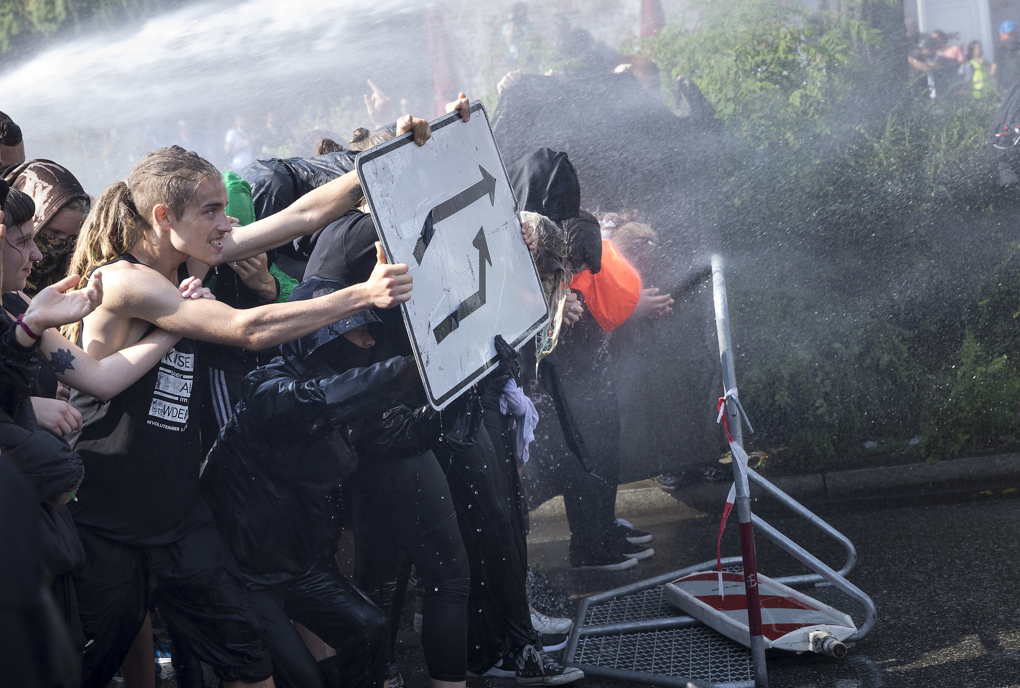 Demonstranten stellen sich am 07/07/2017 an den Landungsbrücken in Hamburg dem Strahl eines Wasserwerfers entgegen. Foto Florian Schuh